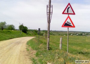 Молдавский знак на дороге о грядущем спуске и повороте